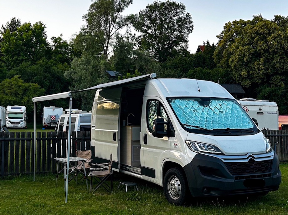 Van in campeggio con veranda aperta con tavolo e sedie.