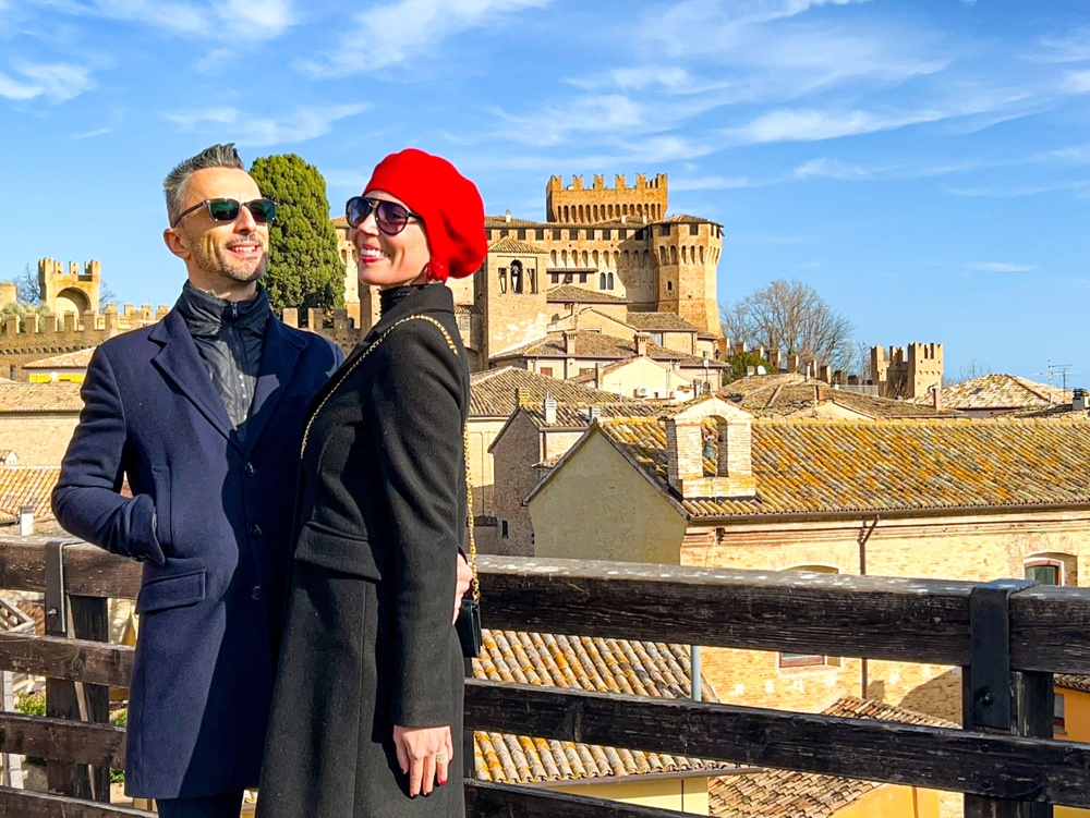 Coppia di fidanzati in posa e dietro di loro la Rocca di Gradara