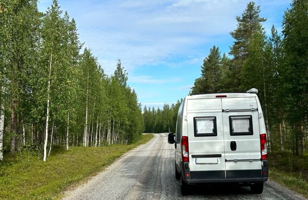 Camper lungo una strada alberata in Finlandia