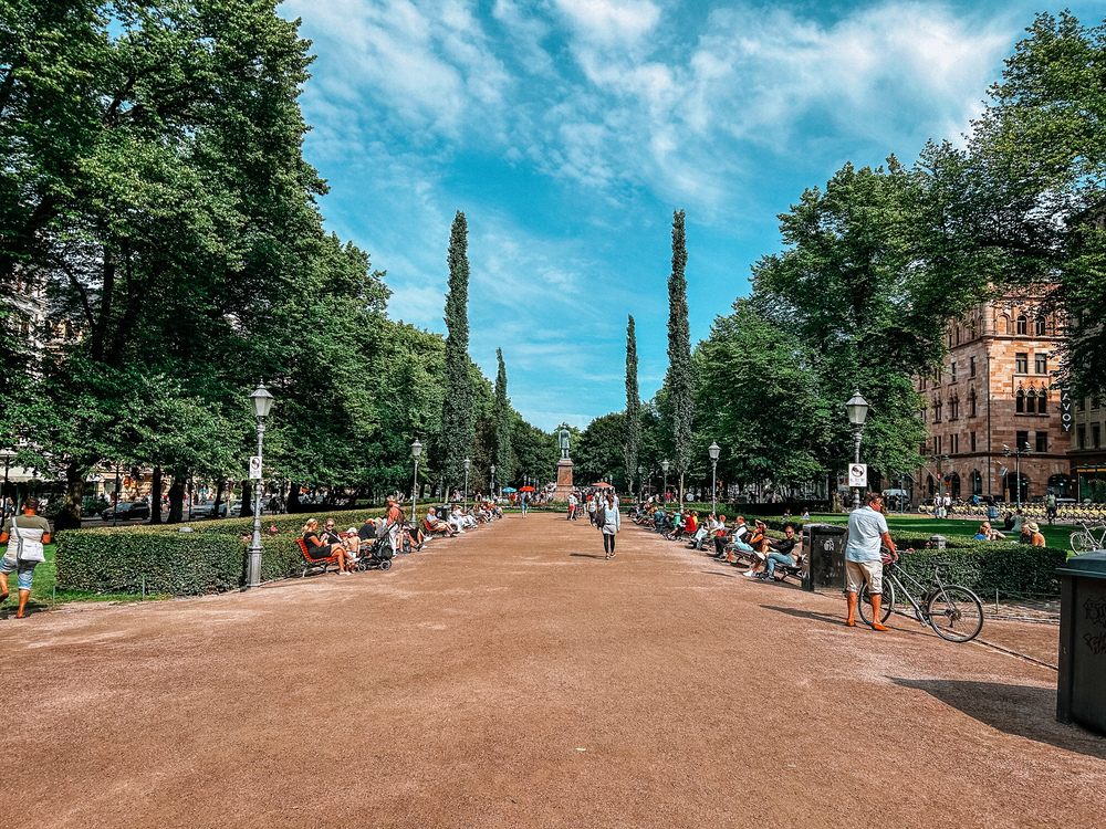 Vista sul Parco Esplanadi in una giornata estiva con persone sedute sulle panchine e altre mentre passeggiano