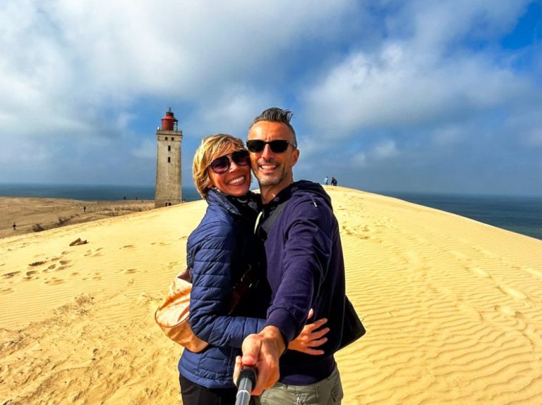 Un selfie vicino al faro tra le dune di sabbia.